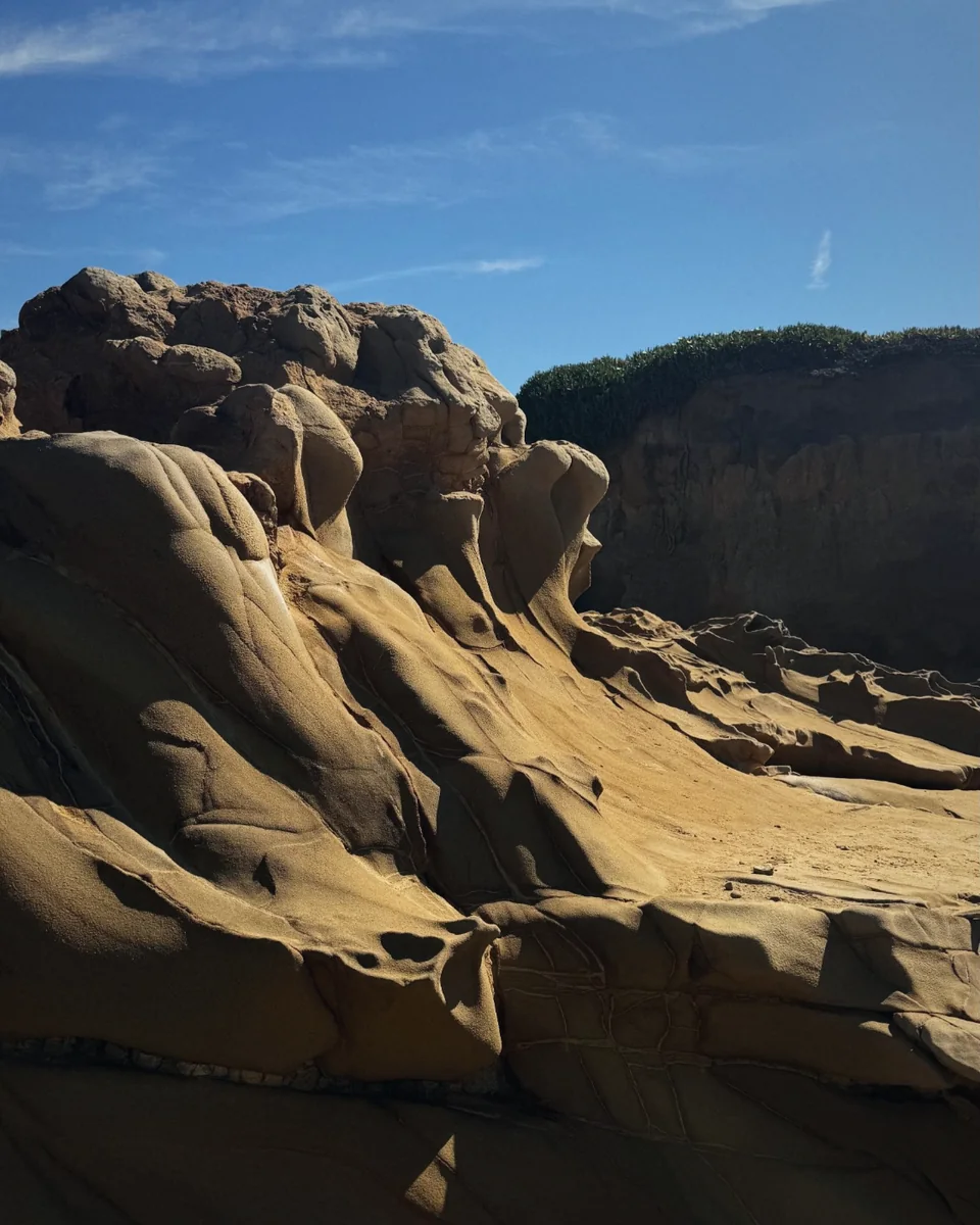 Wind-carved sandstone under a bright blue sky