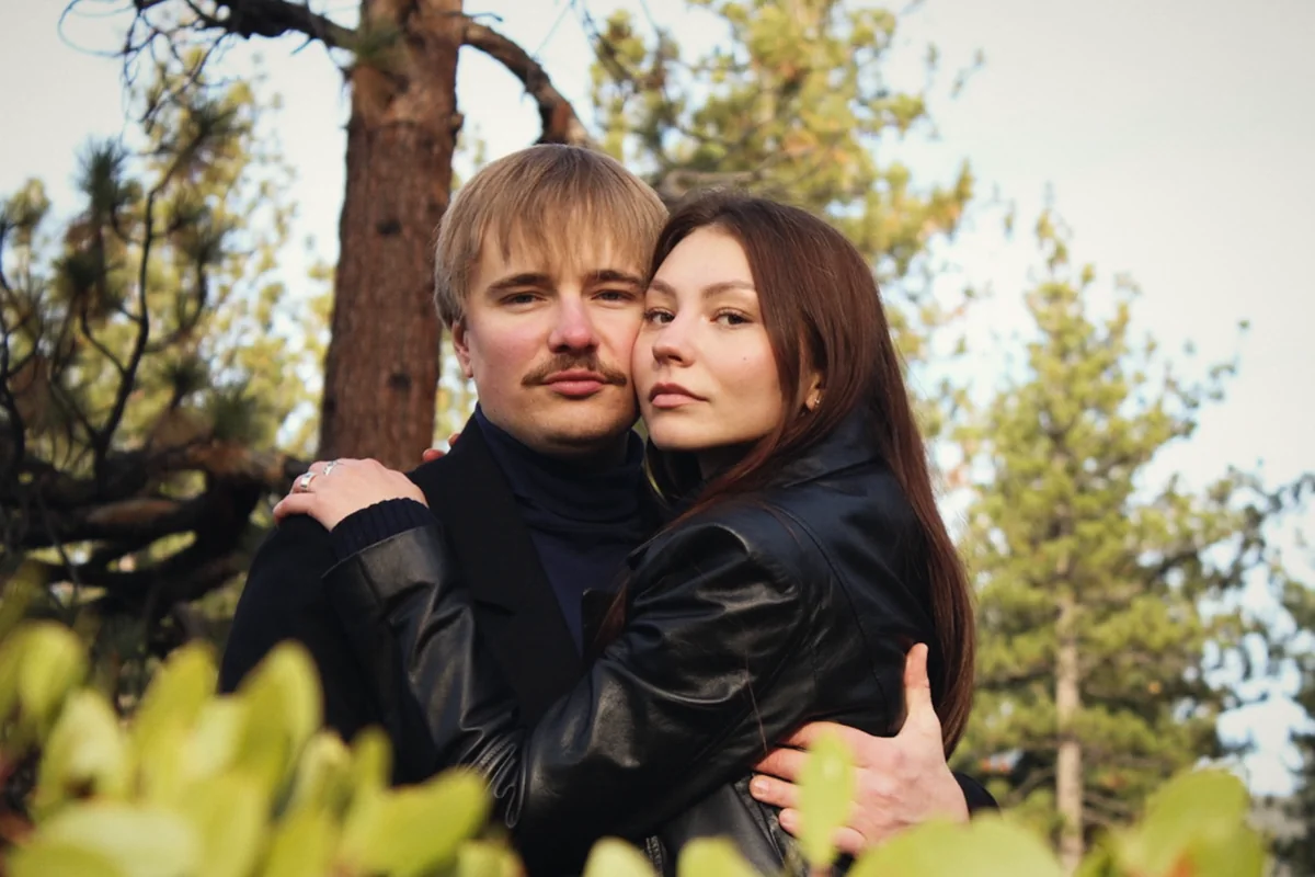 A couple embracing between pine branches